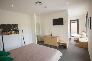 1 dormitorio con 1 cama y TV en la pared en Hotel La Tavernetta, en Campobasso