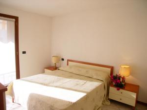 ein Schlafzimmer mit einem Bett, zwei Lampen und einem Fenster in der Unterkunft Alessia in Grado