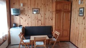 a living room with a couch and chairs and a television at Ваканционно селище Ива in Sarnitsa