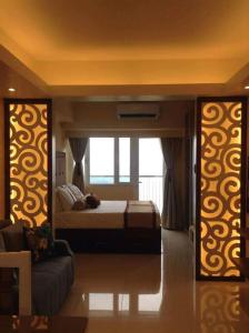 ein Schlafzimmer mit einem Bett und einer Couch in der Unterkunft Elizabeth 1830 @ Wind Residences in Tagaytay