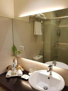 ein Badezimmer mit Waschbecken und Spiegel in der Unterkunft Elizabeth 1830 @ Wind Residences in Tagaytay