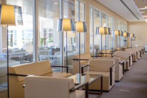 a row of chairs and tables in a room with windows at Hipotels Playa La Barrosa - Adults Only in Chiclana de la Frontera