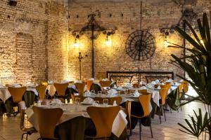 a dining room with tables and chairs and brick walls at Hotel Tavares Correia in Garanhuns