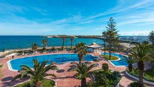 een luchtzicht op een resort met een zwembad en de oceaan bij Regency Hotel & Spa in Monastir