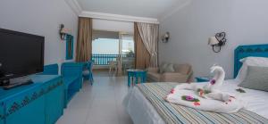 niebiesko-biała sypialnia z łóżkiem i telewizorem w obiekcie Regency Hotel & Spa w mieście Monastir