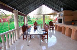 un porche cubierto con mesa y sillas en Green Garden Guest House, en Tskaltubo