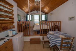 a kitchen and dining room with a table and chairs at Kyklameno Studio no 2 in Symi