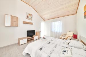 a white room with a bed and a tv at Apartments Gvarda in Umag