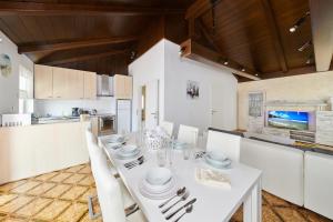 a white dining room with a white table and chairs at Apartments Gvarda in Umag