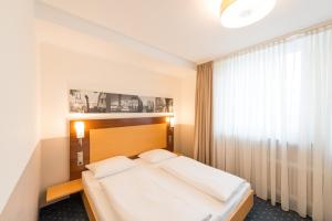 a bedroom with a large bed and a window at Heikotel - Stadtpark Residenz in Hamburg