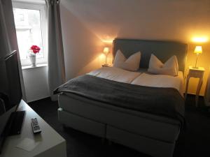 a bedroom with a large bed with white pillows and a window at Hotel Frankfurter Hof in Limburg an der Lahn