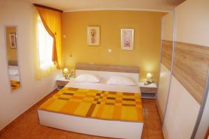 a bedroom with a checkered bed and yellow walls at Holiday apartment in village Dobrani in Rebići
