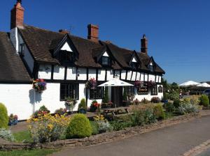 a white building with flowers in front of it at The Fountain Oldwood in Tenbury