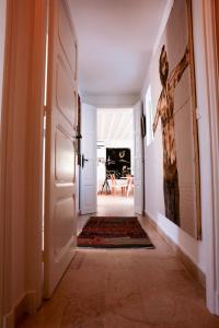 a hallway with a door and a painting on the wall at La Maison De L'artiste in Sidi Bou Saïd