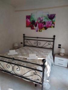 a bedroom with a bed with two paintings on the wall at Il Tulipano in Bergamo