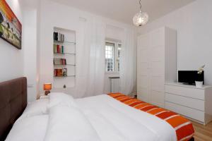 een witte slaapkamer met een bed en een televisie bij Cozy Domar - My Extra Home in Rome