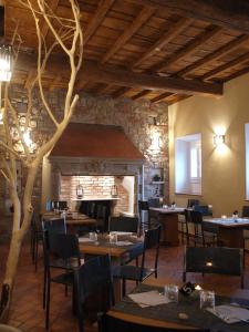 un restaurante con mesas y sillas y una chimenea en B&B Osteria dello sperone, en Lonate Pozzolo