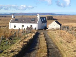 an old house in the middle of a field at La Maison de Campagne in Kilmuir