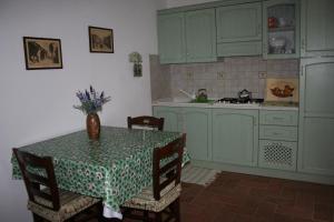 a kitchen with green cabinets and a table with a vase on it at Agriturismo Diciocco in Venturina Terme