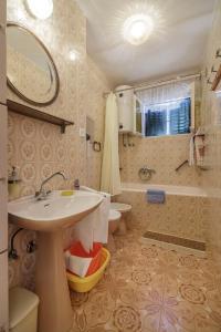 y baño con lavabo, aseo y espejo. en Apartman Željka, en Komiža