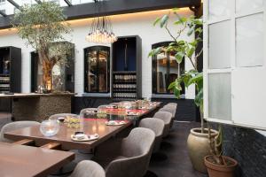 a dining room with tables and chairs and plants at Librije's Hotel in Zwolle