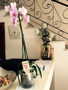 eine Vase mit rosa Blumen auf dem Tisch in der Unterkunft Guest House Neho in Cres