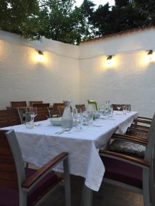 una mesa con un mantel blanco y gafas. en Guest House Neho, en Cres