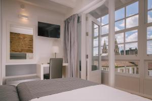 圣地亚哥－德孔波斯特拉Os Sobriños Do Pai的一间卧室，里面有一张床和一扇大窗户。