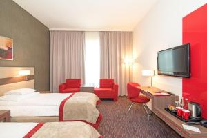 チェラチにあるHotel Szafranのベッド2台、薄型テレビが備わるホテルルームです。