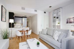マドリードにあるGran Via Apartment by Flatsweethomeの白いリビングルーム(ソファ、テーブル付)