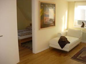 a living room with a white couch and a bed at BUKL29001-FeHaus-Grothhuus in Fehmarn