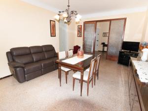 een woonkamer met een tafel en een leren bank bij Belvilla by OYO Can Bertu in Sant Pere Pescador