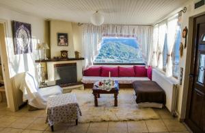 a living room with a pink couch and a window at Country guesthouse Αερικό in Karpenision