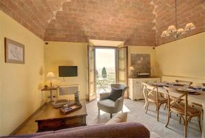 a living room with a table and a dining room at Ville Degli Ulivi in Laiatico
