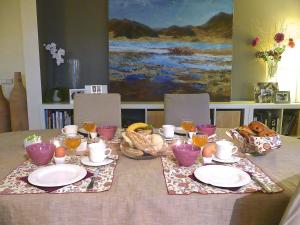 a table with plates and bowls of food and drinks at Le Relais du Moustier in Grune