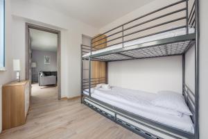a bedroom with two bunk beds and a mirror at Apartamenty Sun & Snow Zwycięstwa in Międzyzdroje