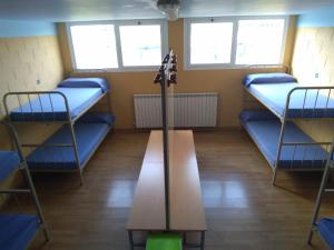 a room with three bunk beds and a table at Albergue De Peregrinos Santiago Apostol in Puente la Reina