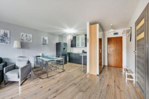 ein Wohnzimmer und eine Küche mit einem Tisch und Stühlen in der Unterkunft Apartamenty Sun & Snow Zwycięstwa in Misdroy