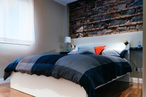 a bedroom with a brick wall and a bed at b&b le 4 leggende in Catania