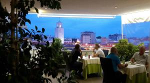 un grupo de personas sentadas en mesas en un restaurante en Hotel Europa, en Latina