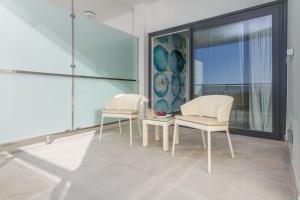 two chairs and a table in a room with a window at ESTIMAR Calpe Suitopia in Calpe