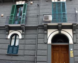 un edificio con 2 ventanas y una puerta de madera en Casa Vacanze Velia, en Salerno