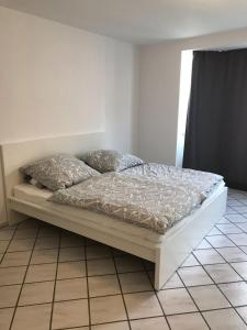 a bed sitting on a tiled floor in a bedroom at AVI Deluxe Altstadt Apart in Düsseldorf
