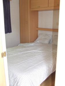 NeuvicにあるStacaravan 6 persoons - Camping Le Soustranのベッドルーム1室(白い掛け布団付きのベッド1台付)