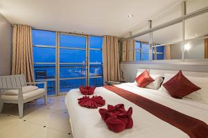 a hotel room with two beds with red pillows on them at Enjoy Beach in Bophut 