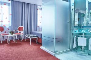 a room with a bed and a table and chairs at Continental Forum Sibiu in Sibiu