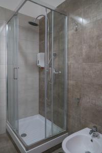 a shower with a glass door next to a sink at B&B Posidonia Salerno in Salerno