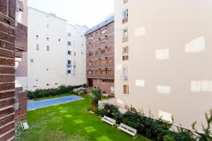 マドリードにあるVillanueva Apartments by Flatsweethomeの芝生とベンチのある建物の中庭