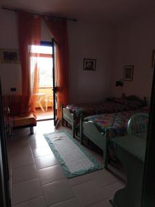 1 dormitorio con 2 camas y ventana en B&B da Donatella, en Santa María