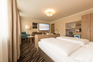 a hotel room with two beds and a flat screen tv at Heikotel - Hotel Windsor in Hamburg